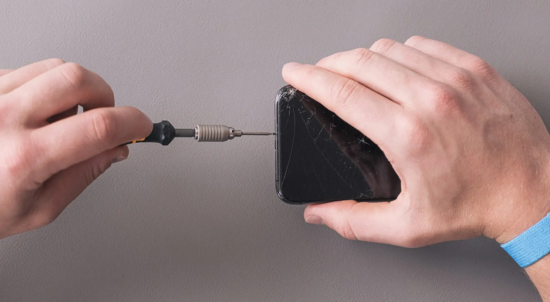 A phone screen being replaced on a repair bench